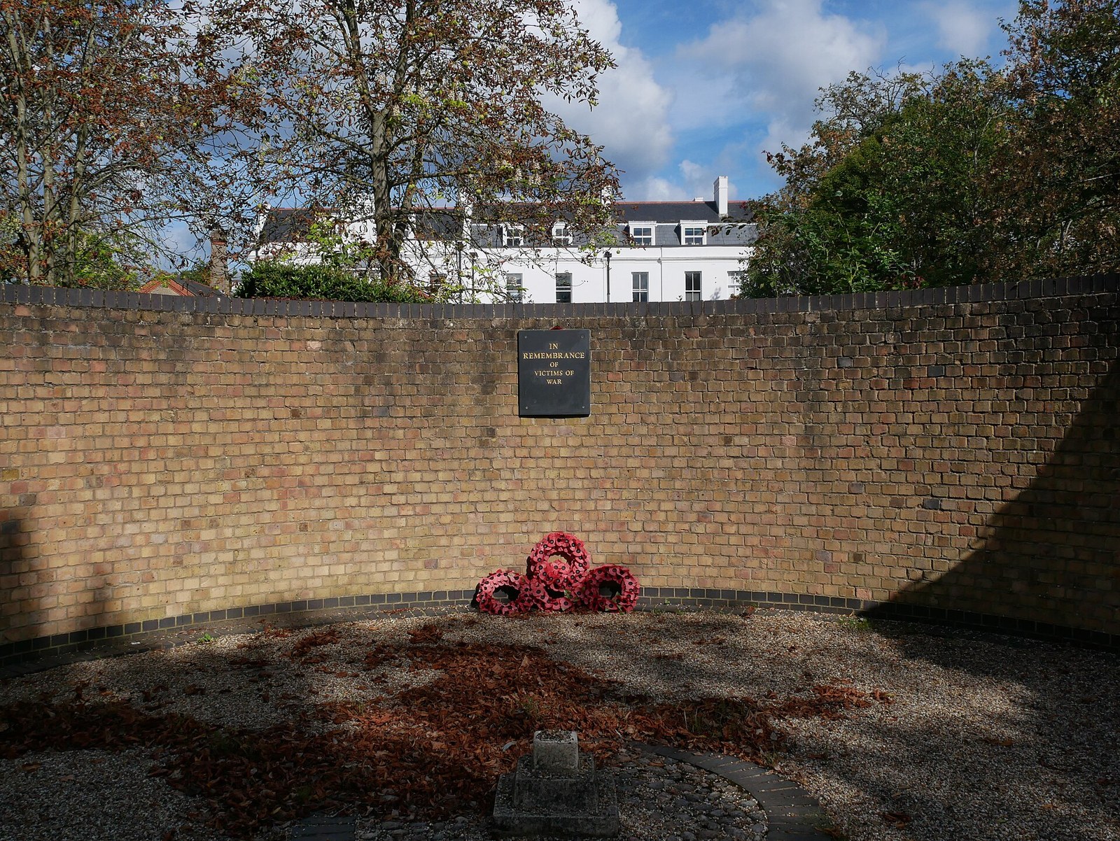 The brick-walled memorial garden on Snaresbrook Road, with a poppy wreath laid at its foot
