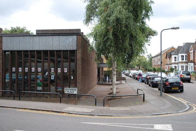 Wanstead Library from the corner of the street, with trees and a parked car