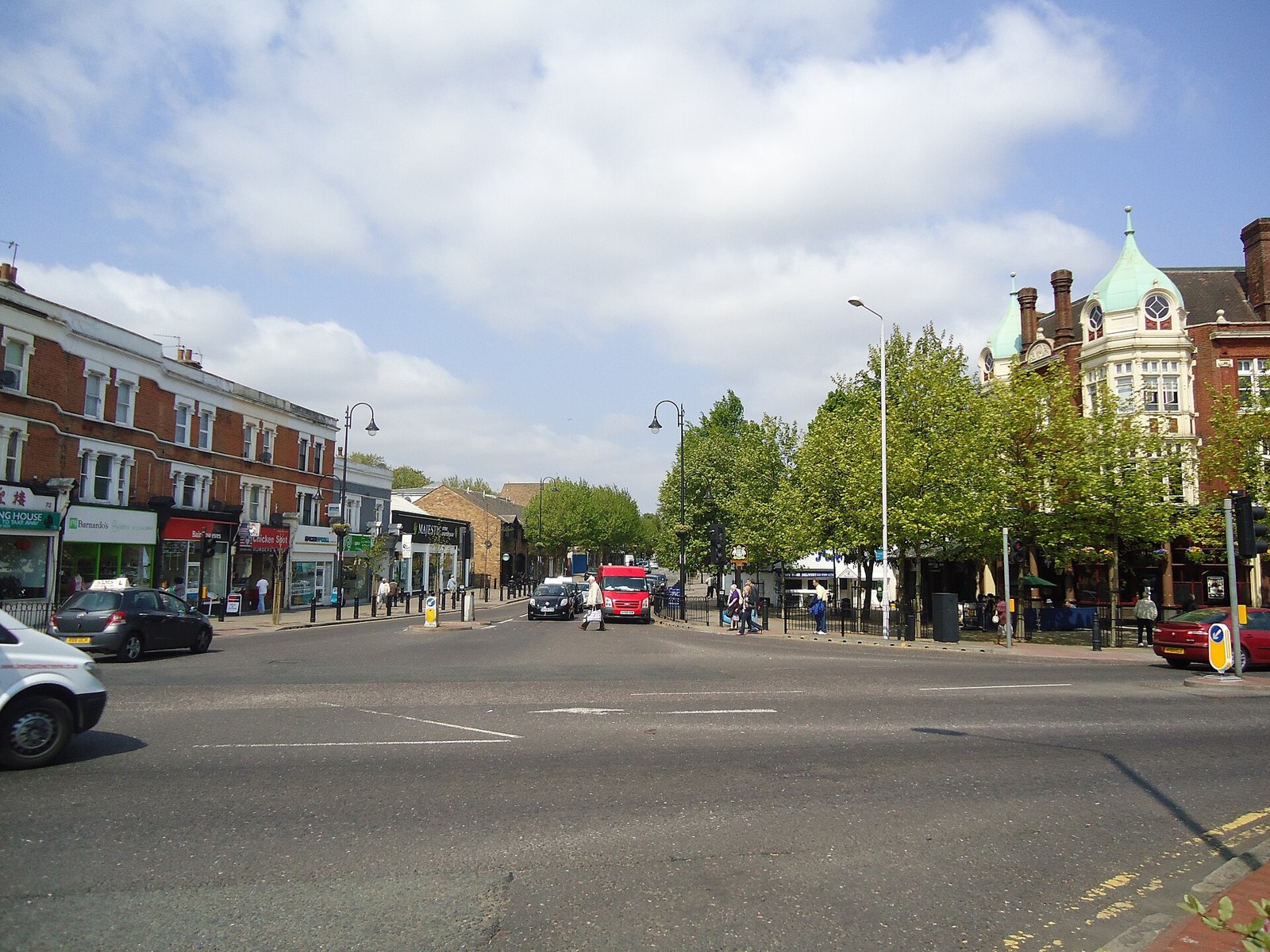 Wanstead High Street on a sunny day, with shops and parked cars