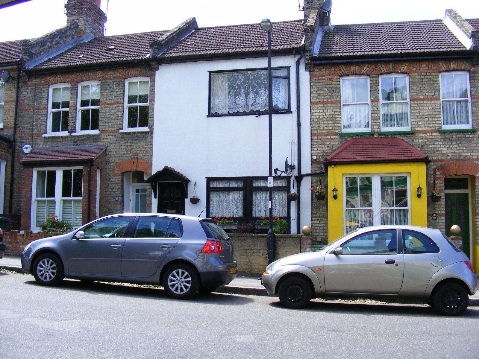A row of brick Victorian terraced houses in Wanstead with cars parked outside