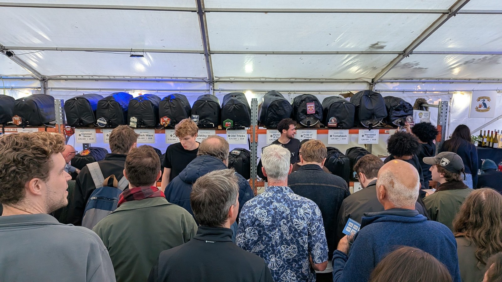 A packed marquee at the fourth Wanstead Beer Festival with rows of casks behind the crowd