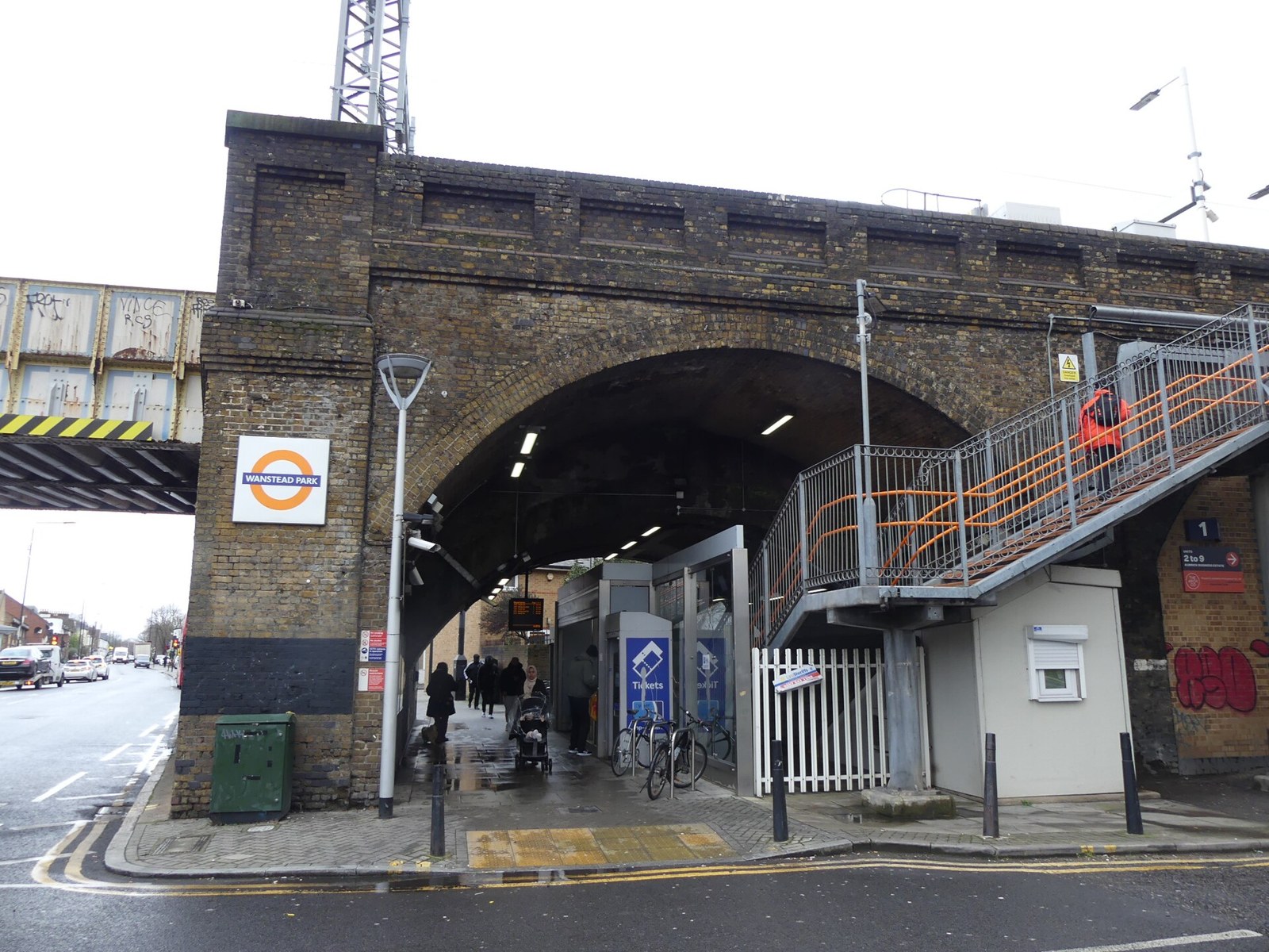 The brick viaduct entrance to Wanstead Park station on Woodgrange Road with an Overground roundel