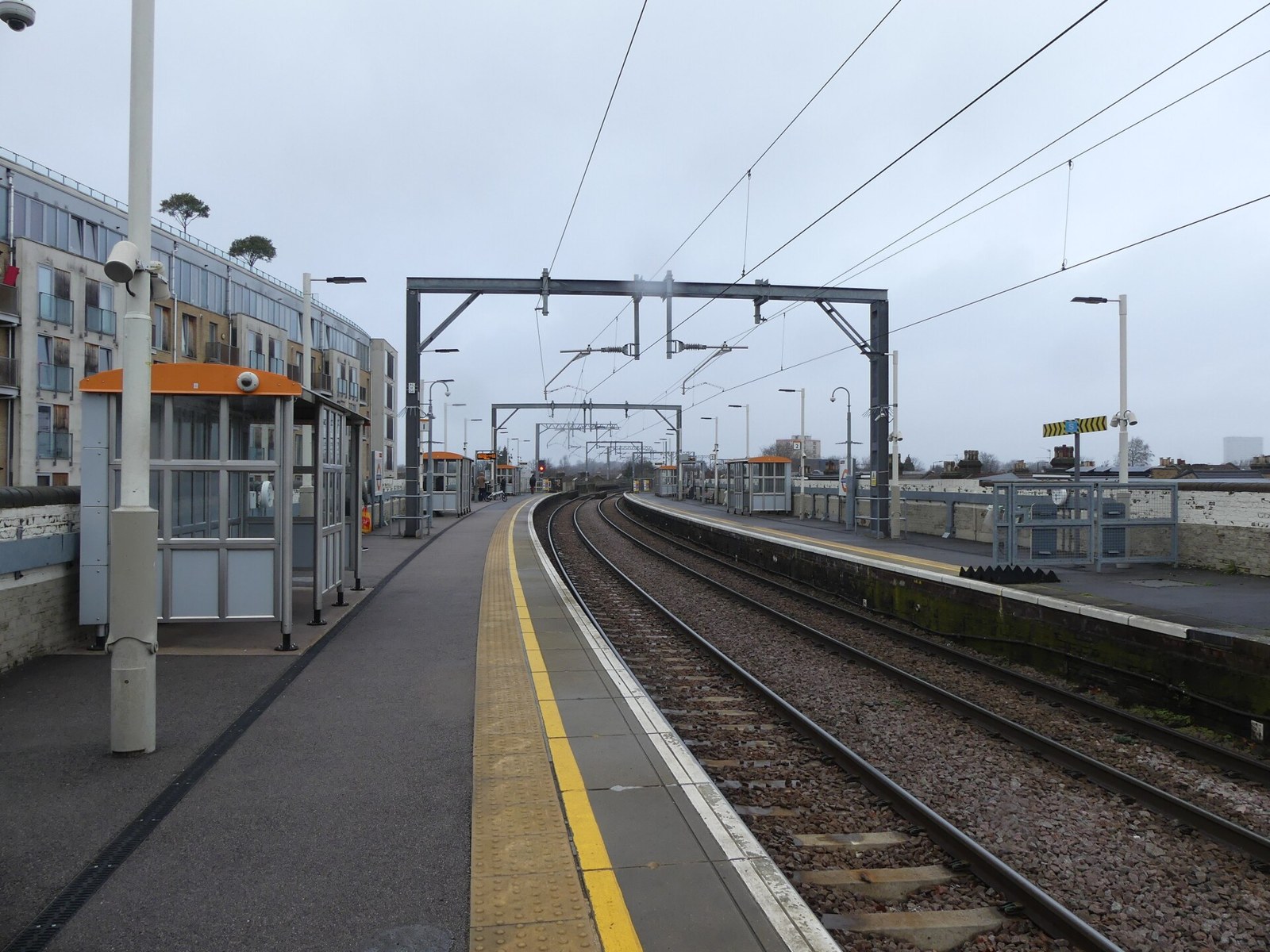 The platforms at Wanstead Park station looking west, with overhead wires and a shelter